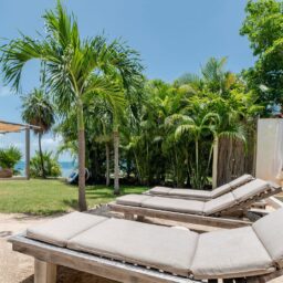 Sun loungers and palm trees by the sea — Casa Coco, Isla Mujeres, Mexico