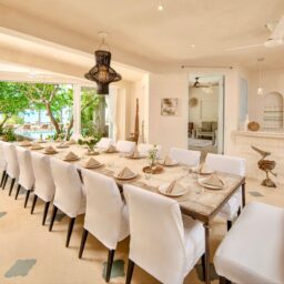 Dining area with long table and white chairs — Casa Coco, Isla Mujeres, Mexico