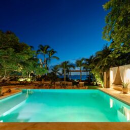 Illuminated pool at dusk — Casa Coco, Isla Mujeres, Mexico