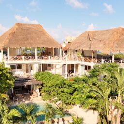Villa exterior with palapa rooftops — Casa Coco, Isla Mujeres, Mexico