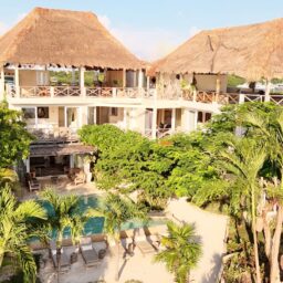 Villa exterior with palapa rooftops — Casa Coco, Isla Mujeres, Mexico