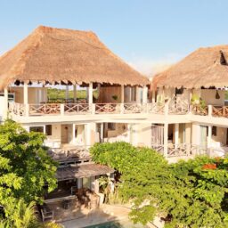 Villa exterior with palapa rooftops — Casa Coco, Isla Mujeres, Mexico