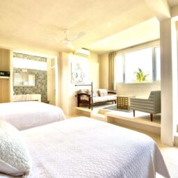 Bedroom with two beds and sitting area — Casa Coco, Isla Mujeres, Mexico