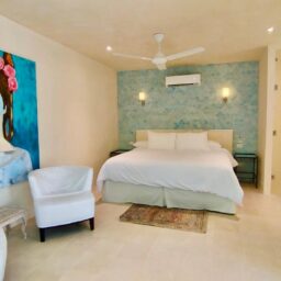 Bedroom with bed and blue accent wall — Villa Encantada, Isla Mujeres, Mexico