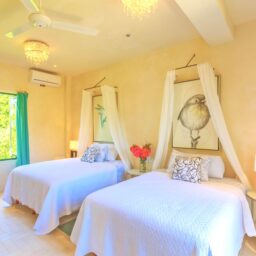Bedroom with two beds and canopy — Villa Encantada, Isla Mujeres, Mexico